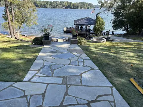 Flagstone walkway running down to a dock on the lake